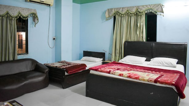 Een slaapkamer met een bed, een stoel en een airconditioning.