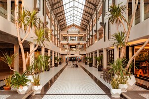 A spacious atrium with a high ceiling, large windows, and a central seating area.