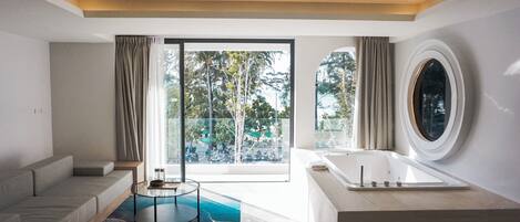 A modern bathroom with a bathtub, a glass shower enclosure, and a large window providing a view of the outdoors.