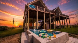 Ein Resort mit Pool, einem Schild für BolivarVacations.com und Blick auf den Sonnenuntergang.