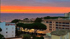 A coastal view with a sunset, buildings, and a parking area. - Perla del Mar - one step from the beach and center of Platja d'Aro (Castell-Platja d'Aro)