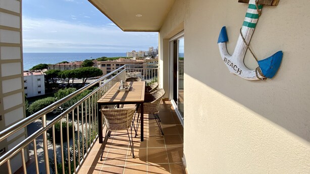 A balcony with a view of the sea, a table with chairs, and a decorative anchor on the wall. - Perla del Mar - one step from the beach and center of Platja d'Aro (Castell-Platja d'Aro)