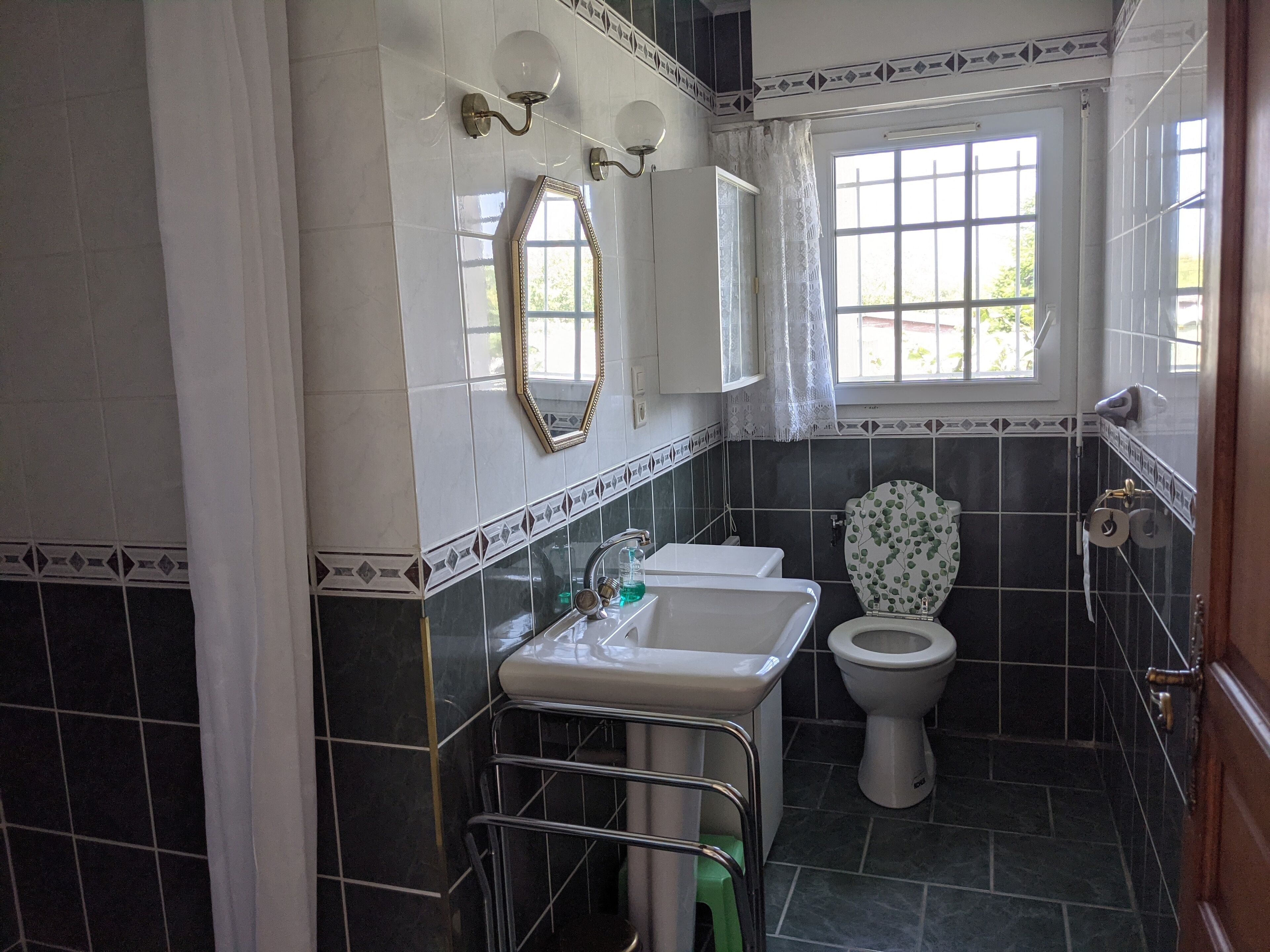A bathroom with a white sink, a toilet, and a mirror.