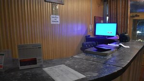 A reception desk with a computer monitor, a check-out sign, a calendar, and a menu. - Gilgit Gateway Hotel (Gilgit)