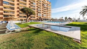Un hôtel doté d’une piscine, d’un espace verdoyant et d’un grand bâtiment avec de nombreux balcons.