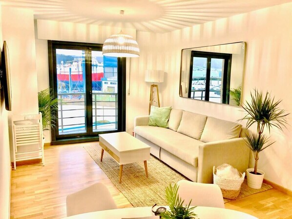 A modern living room with a sofa, coffee table, and potted plants.