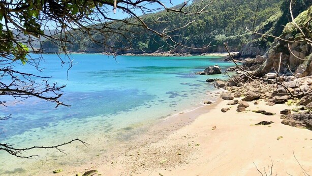 A beach with clear turquoise water, sandy shore, and rocky outcrops. - The Cliffs - Sunset Village Beach 3E (Viveiro)