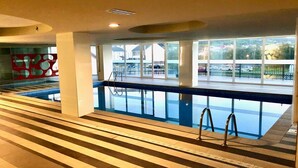 A swimming pool area with clear glass walls, a tiled floor, and a railing. - The Cliffs - Marina Sol te hará soñar (Viveiro)