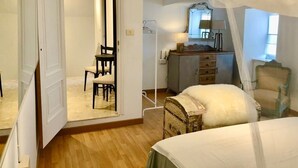 A bedroom with a bed, a chair, a dresser, and a mirror. - The Cliffs - Le Village Sarridal (Ortigueira)