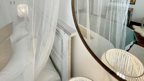 A bedroom with a bed, a round mirror, and a white canopy. - The Cliffs - A Casa de Mercedes (Mañon)