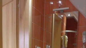 Un baño con inodoro, bidé y lavamanos con espejo arriba.