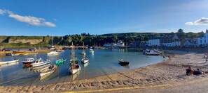 A coastal marina with boats docked, a sandy beach, and buildings in the background. - Stonehaven Scotland Beachfront House - Stunning Sea and Beach Views (Stonehaven)