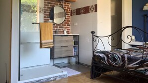 A bedroom with a bed, a window, a mirror, a sink, and a door. - Cosy house in peaceful setting 10 minutes from Avignon (Le Pontet)