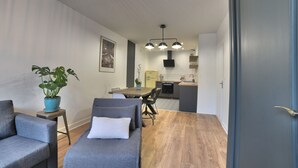 A modern living room with a sofa, a small table, and a potted plant. - Magnificent T2 hyper center, hyper equipped (La Rochelle)
