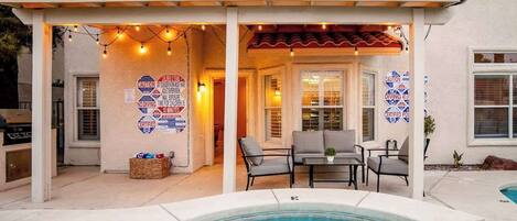 A pool area with a covered patio, outdoor seating, and multiple caution signs.