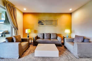A modern living room with a sofa set, a coffee table, and two lamps. - Magical Village Gem (Kissimmee)