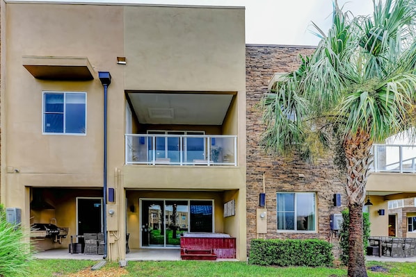 A two-story building with a flat roof, a balcony on the upper floor, and a small front porch area. - Magical Village Gem (Kissimmee)