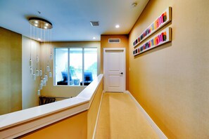 A hallway with a white reception desk, a window with a view, and a door.
