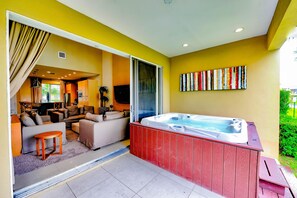A modern living room with a sofa, a coffee table, and a hot tub.