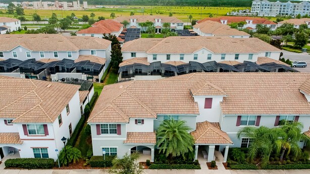 Un quartier résidentiel composé de plusieurs maisons à deux étages, chacune ayant un toit en tuiles et un petit jardin devant.