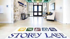 Un hall d’hôtel avec un mur en pierre, un comptoir d’accueil et une enseigne indiquant « STOREY LAKE ».