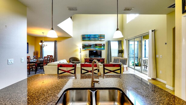 A modern kitchen with granite countertops, stainless steel sink, and pendant lighting. - Paradise Palms Resort, Just Minutes From Disney!!!! (Kissimmee)
