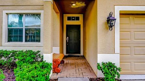 A house entrance with a door, a window, and a garage door. - Paradise Palms Resort, Just Minutes From Disney!!!! (Kissimmee)