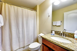 A bathroom with a shower curtain, toilet, sink, and mirror. - Paradise Palms Resort, Just Minutes From Disney!!!! (Kissimmee)
