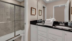 A modern bathroom with a glass-enclosed shower, two sinks, and a large mirror. - Luxurious Vacation Home With Private Pool!!! (Kissimmee)