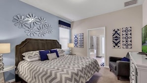 A bedroom with a bed, a nightstand, a dresser, and a chair. - Luxurious Vacation Home With Private Pool!!! (Kissimmee)