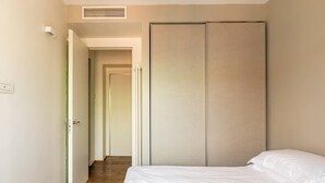 Ein Schlafzimmer mit Bett, Kleiderschrank und Flur.