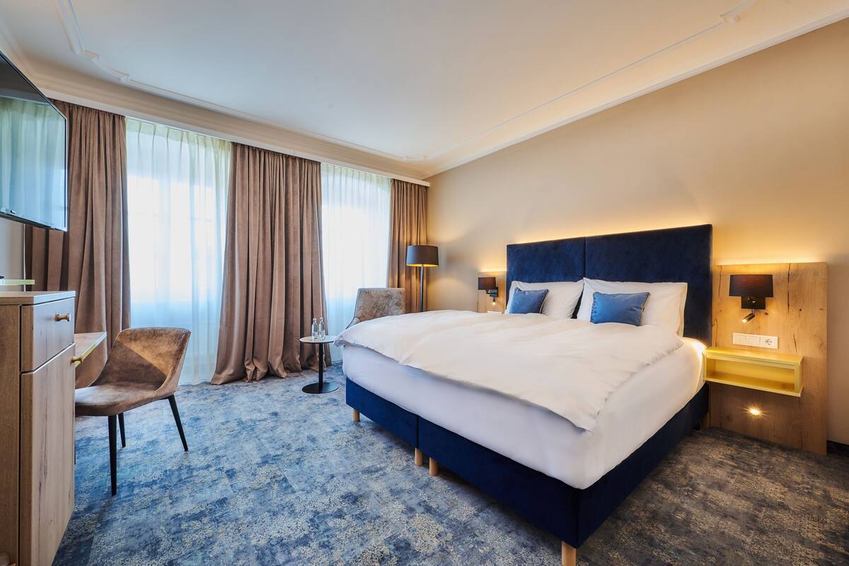أغطية فراش متميزة وألحفة محشوة بالريش وميني بار وخزنة داخل الغرفة