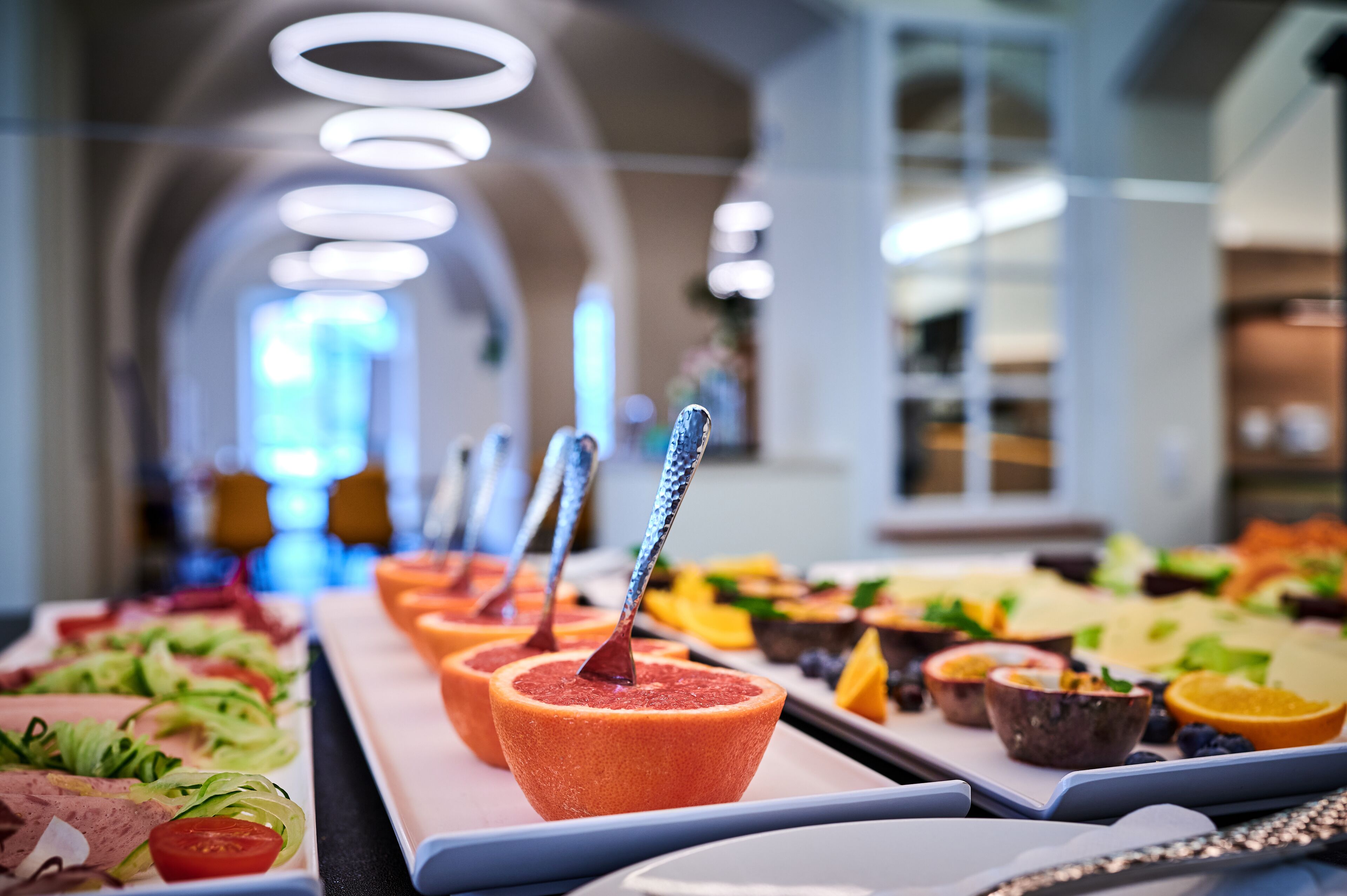 A buffet with various food items and a spoon in a bowl.