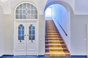 A staircase with a handrail and a carpeted landing.