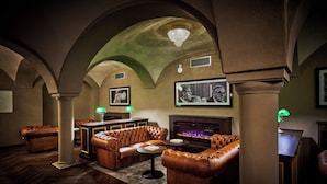 A luxurious lounge with leather sofas, a fireplace, and a chandelier. - Hotel Zur Post Altötting (Altötting)