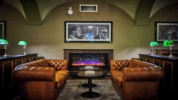 Cómoda sala de estar con sofás de cuero, una chimenea y obras de arte enmarcadas en la pared.