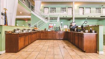 Welcome to our hotel lobby, featuring a central island with a long counter and staircase connecting two levels.