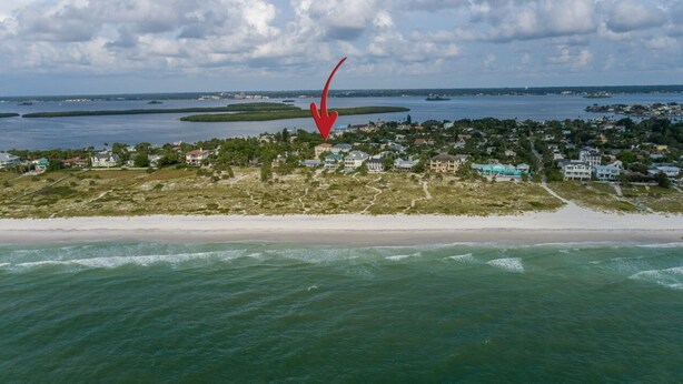 A coastal town with a beach, houses, and a body of water.