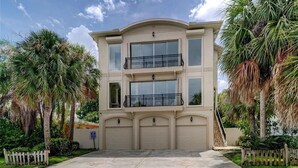A two-story building with a flat roof, large windows, and a garage.