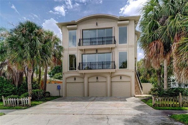 A two-story building with a flat roof, large windows, and a garage.
