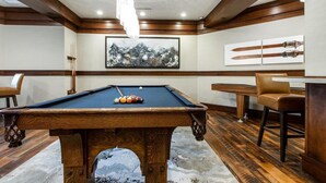 A pool table in a room with wooden beams, a framed painting, and a table with chairs. - Deer Valley Ski Condo with Parking (Park City)