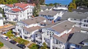 Un quartier résidentiel composé de plusieurs maisons à deux étages, chacune dotée de balcons et offrant une vue sur la mer.