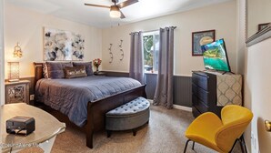 A bedroom with a bed, a television, a desk, and a chair. - Almost paradise (Coeur d'Alene)