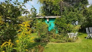 A garden with a small blue shed, surrounded by various plants and trees. - Vacation apartment in Wermelskirchen, Bergisches Land, near Cologne and Düsseldorf (Wermelskirchen)