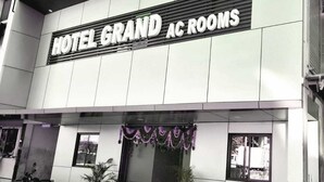 Un edificio con un cartel que dice "HOTEL GRAND AC ROOMS".