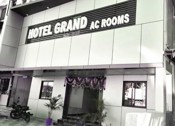 A building with a sign reading "HOTEL GRAND AC ROOMS". - Hotel Grand (Vadodara)