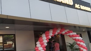 El exterior de un hotel con un arco grande de globos rojos y blancos sobre la entrada.
