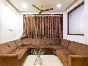 Habitación Deluxe | Área de sala de estar | Televisión LED de 30 pulgadas con canales por cable y televisión
