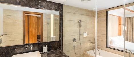 A modern bathroom with a large mirror, a sink, a shower, and a bathtub.