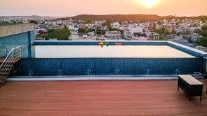 A rooftop swimming pool with a view of a cityscape at sunset. - Radisson Bhopal (Bhopal)